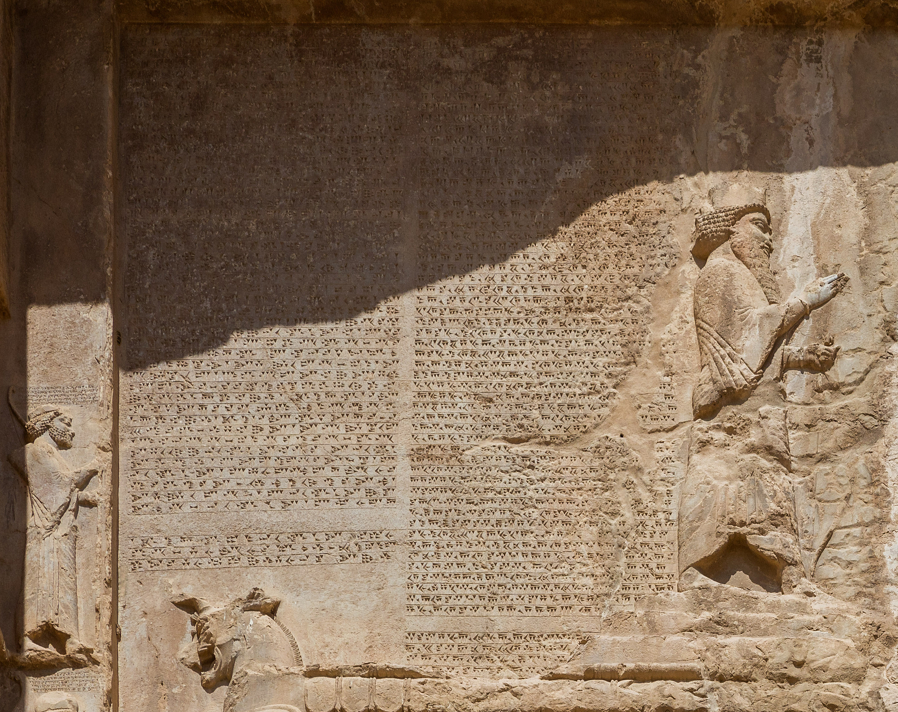 dense cuneiform with sculpted figurines to the left, right, and bottom.